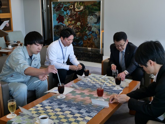 コーヒーやジュースを飲みながら語らう小野市長（左から３人目）と若手職員＝伊東市役所